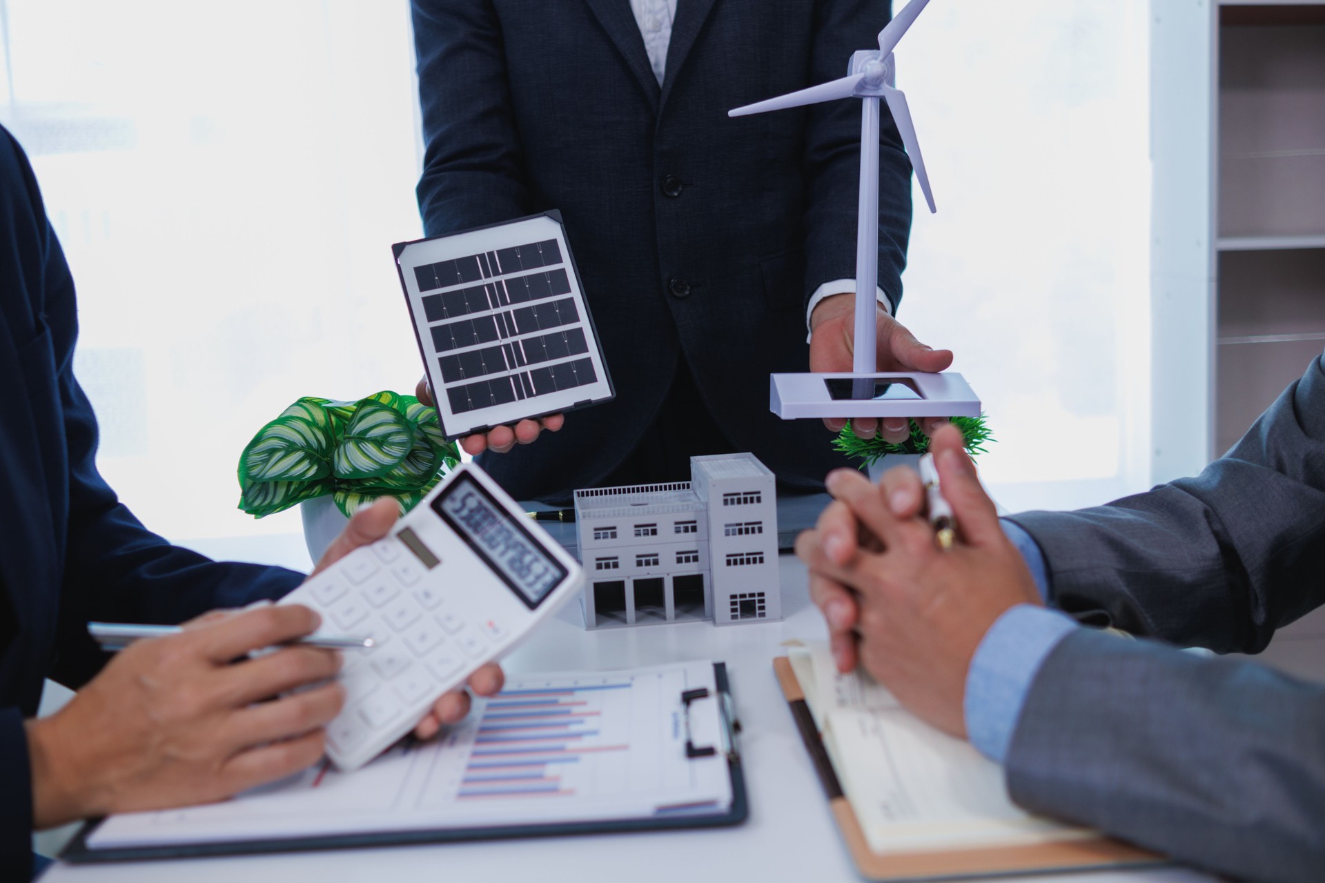 Businessmen, investors and electrical engineers discuss clean energy residential projects help reduce global warming and use clean energy from wind and sunlight. concept clean energy projects