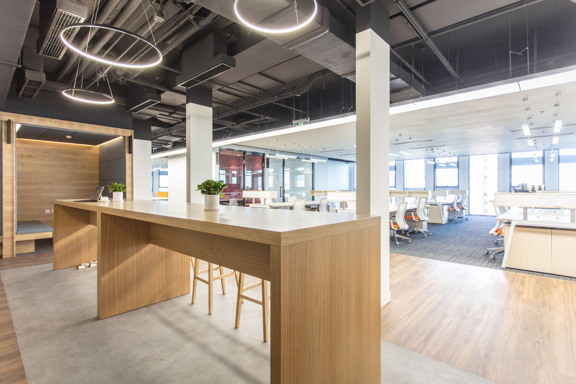 Modern office interior with long wooden table and high stool